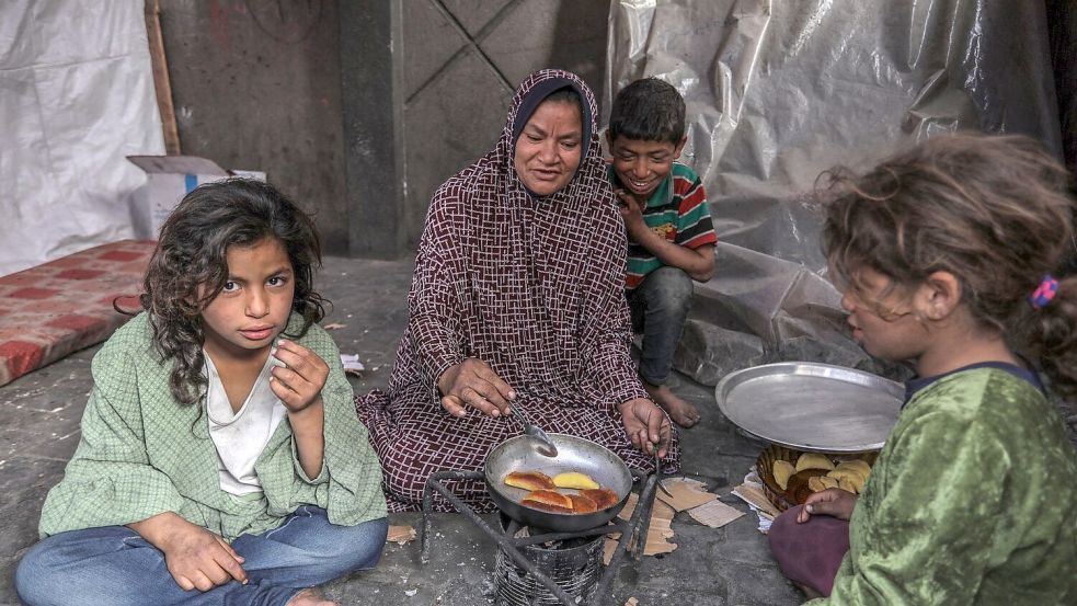 Eine palästinensische Familie kocht in einem behelfsmäßigen Zelt in Rafah. Foto: Abed Rahim Khatib/dpa